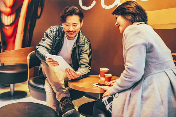 Ảnh minh họa: Khách hàng tham khảo các món trà trên menu quán cà phê.